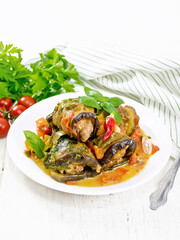 Rolls of eggplant with mincemeat in plate on light board