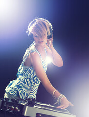 Woman, dj and turntable with headphones for mixing on stage for concert, music and gig at rave...