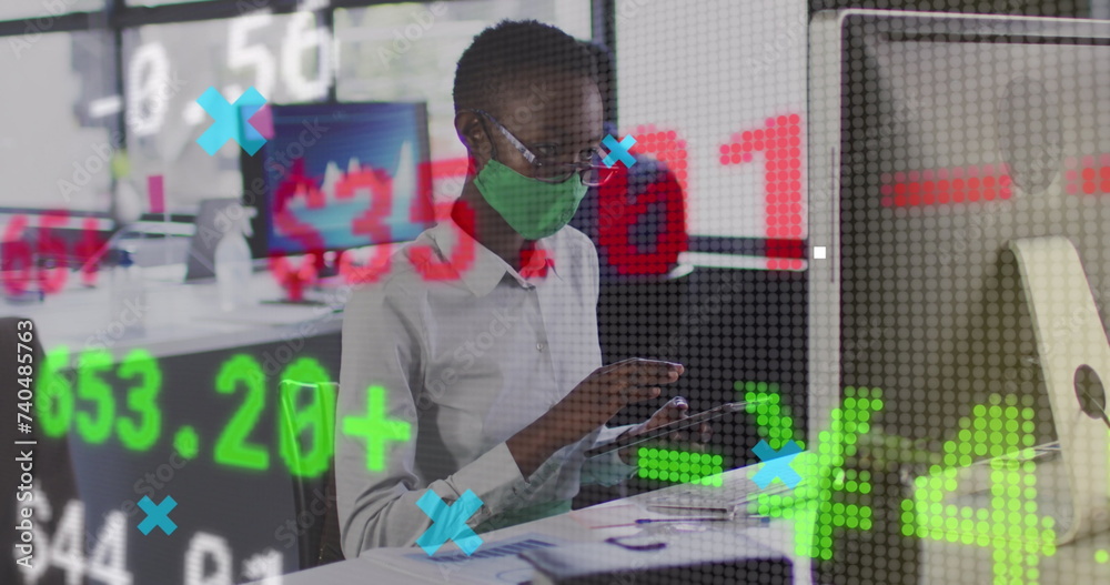 Wall mural Image of financial data processing over businesswoman with face mask using computer in office