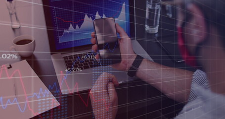 Image of financial data processing over businessman with face mask using smartphone in office