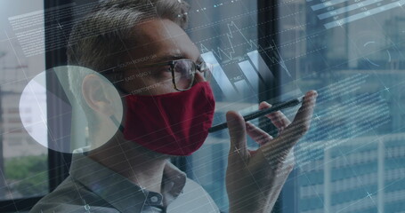 Image of financial data processing over businessman with face mask using smartphone in office
