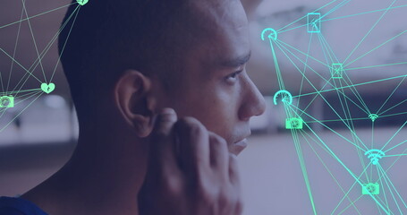 Image of network of media icons over male athlete exercising outdoors with wireless earphones
