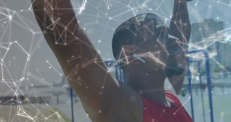 Image of network of communication over smiling male athlete lifting weights outdoors