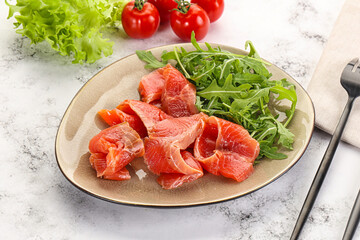 Sliced salmon with fresh arugula