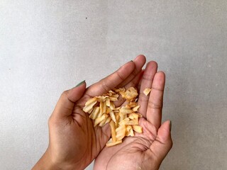 Hand holding Crispy corrugated potato chips or potato chips background. Junk food. Close up