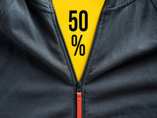 Opened zipper of a hoodie showing 50 percent sale offer on yellow price tag. Sale discount on fashion outlet and clothing price promotion.