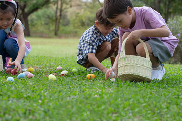 Children have fun collecting Easter eggs on the grass at the park, Easter egg hunt concept