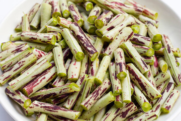 Green purple yard long bean on white plate
