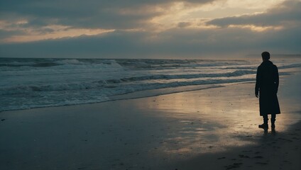 Naklejka premium A person stands on a deserted beach, their back to the ocean