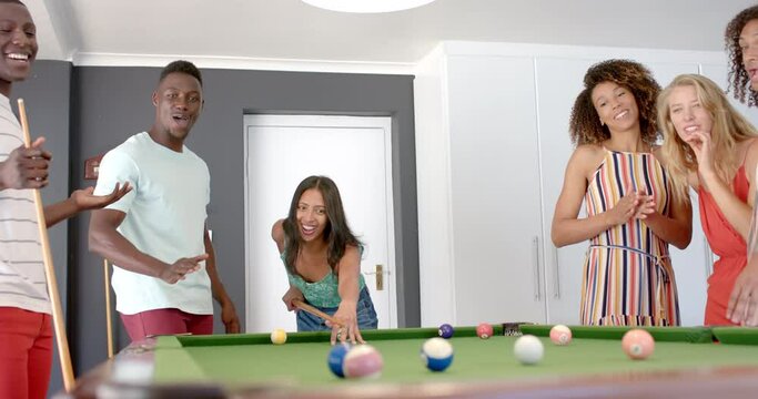 Diverse group enjoys a game of pool at home