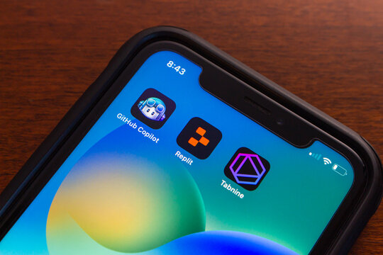 Vancouver, CANADA - Feb 14 2024 : Github Copilot, Replit and Tabnine icons seen in iPhone screen. Generative AI technology, productivity and AI cloud computing concept