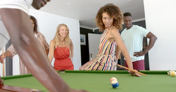 Diverse group of friends enjoy a game of pool at home