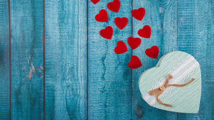 Valentine's Day concept banner with handmade gift box, and a lot of hearts on a blue wooden...