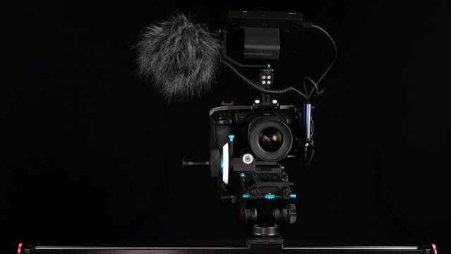 Movie camera with full rig moving from left to right on a slider