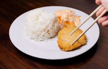 Rice with chicken katsu in white plate on wooden table. After some edits.