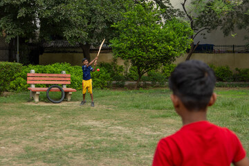 Pre-adolescent boys playing cricket in the park
