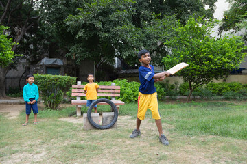 Portrait of boy playing cricket in the park