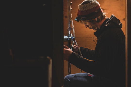 Side view of handyman working on installing a shower, bus conversion