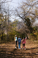 Girls on fall hike look up at trees and enjoy nature and wilderness