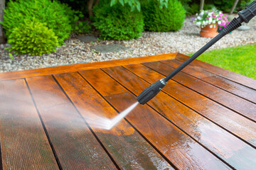 cleaning terrace with a power washer - high water pressure cleaner on wooden terrace surface. - 740525916