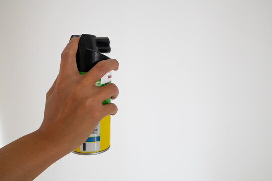 Hand holding an aerosol can of insecticide. Mosquito or insect spray with white background.
