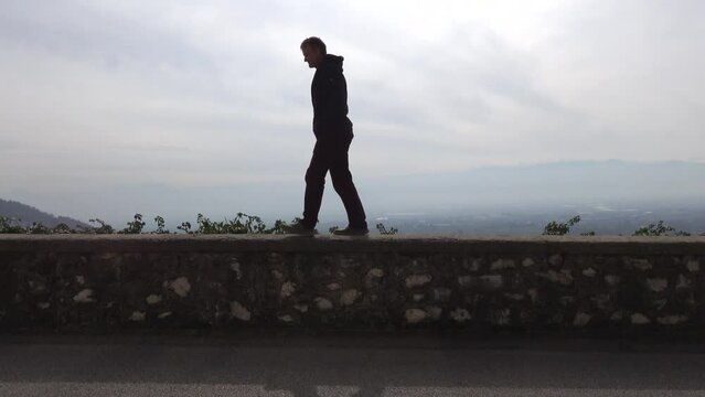 Celano, Italy A man walks on a narrow stone wall in the city 