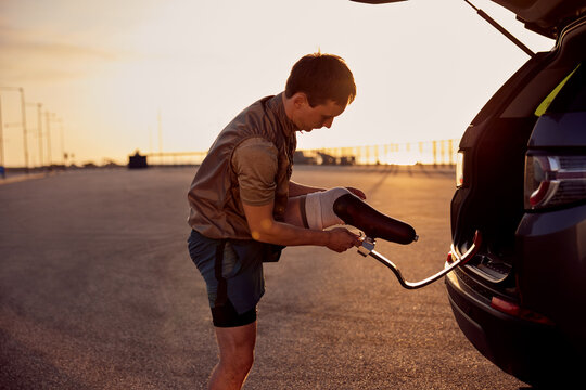 Man attaching a prosthetic running blade before a morning run