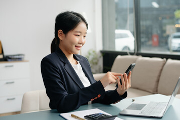 Young beautiful woman typing on tablet and laptop while sitting at the working white table