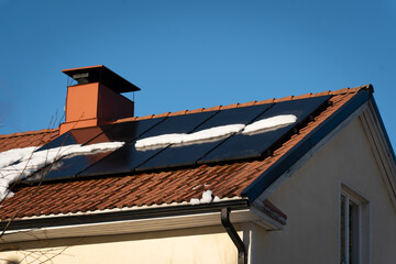 solar panels on top of home roof with snow