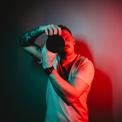 Photographer Holding Camera, Engulfed in Striking Red and Blue Illumination in Secluded Location