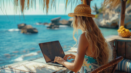 A woman works on her laptop at a tropical beachfront hut, embracing the digital nomad lifestyle with an ocean view.