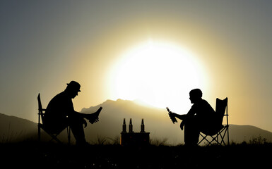 Tables and views of two friends chatting while drinking at sunset