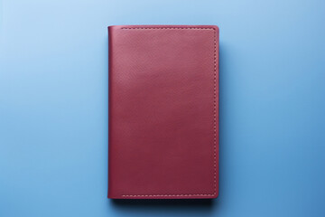 Notebook in a red leather cover on a blue background. Generated by artificial intelligence