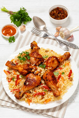 fried chicken drumsticks over rice pilaf, top view
