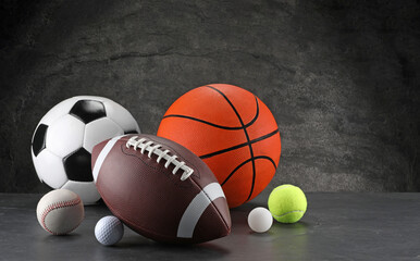 Many different sports balls on dark gray background, space for text