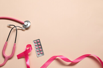 Breast cancer awareness. Pink ribbon, stethoscope and pills on beige background, flat lay. Space...