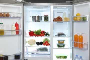 Modern open refrigerator full of different products indoors