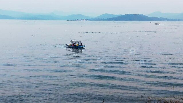 Aerial view of Lake Patratu in Jharkhand India in summer, people in slow boats moving on the Lake water with bubbles flying in the air. Famous landmark, and travel destination. India