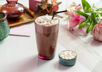 Cappuccino coffee with marshmallows in a transparent glass.