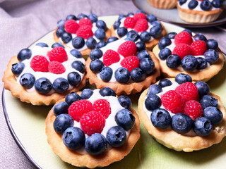 Freshly baked baskets with curd cream and strawberries	