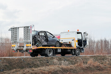 T-Bone Car Accident. Side crashed modern family car. Tow truck with a broken car on a road. Tow...