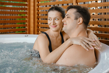 A happy married couple relaxes at the jacuzzi on a joint vacation