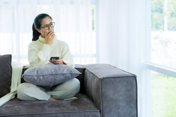Fototapeta premium Woman spend time at home seated on sofa