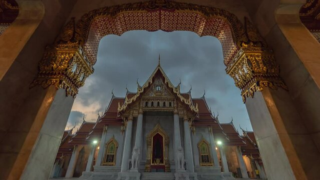 Time lapse Looking through the Beautiful gate of Wat Benchamabophit. It is a temple with exquisite architecture. Beautiful and a landmark of Bangkok Thailand. cloud moving in beautiful sunrise.