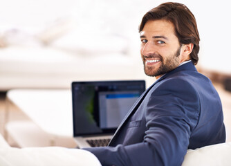 Happy, portrait and businessman with remote work on sofa with laptop in home or living room. Entrepreneur, smile and working in lounge with computer for online research, report or journalist writing