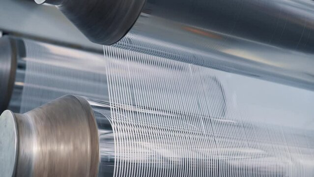 Operation of a flat-slot extruder in the production of polypropylene bags. Close-up of cut threads.