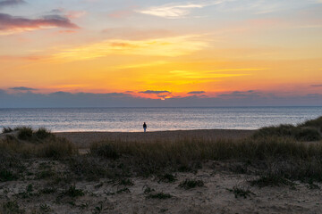 Un coucher de soleil envoûtant baigne une plage du Finistère sud en Bretagne, tandis qu'une...