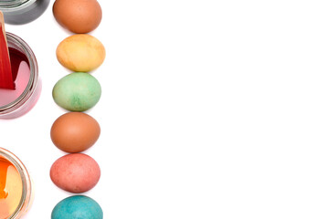 Kolorowe jajka wielkanocne i barwniki ułożone równo po lewej stronie kadru, białe tło - obrazy, fototapety, plakaty