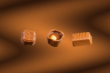 Delicious chocolate candies on brown background