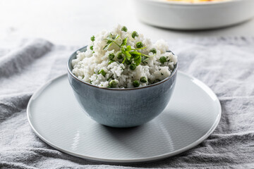 Jasmine rice with peas and parsley in a bowl on the table